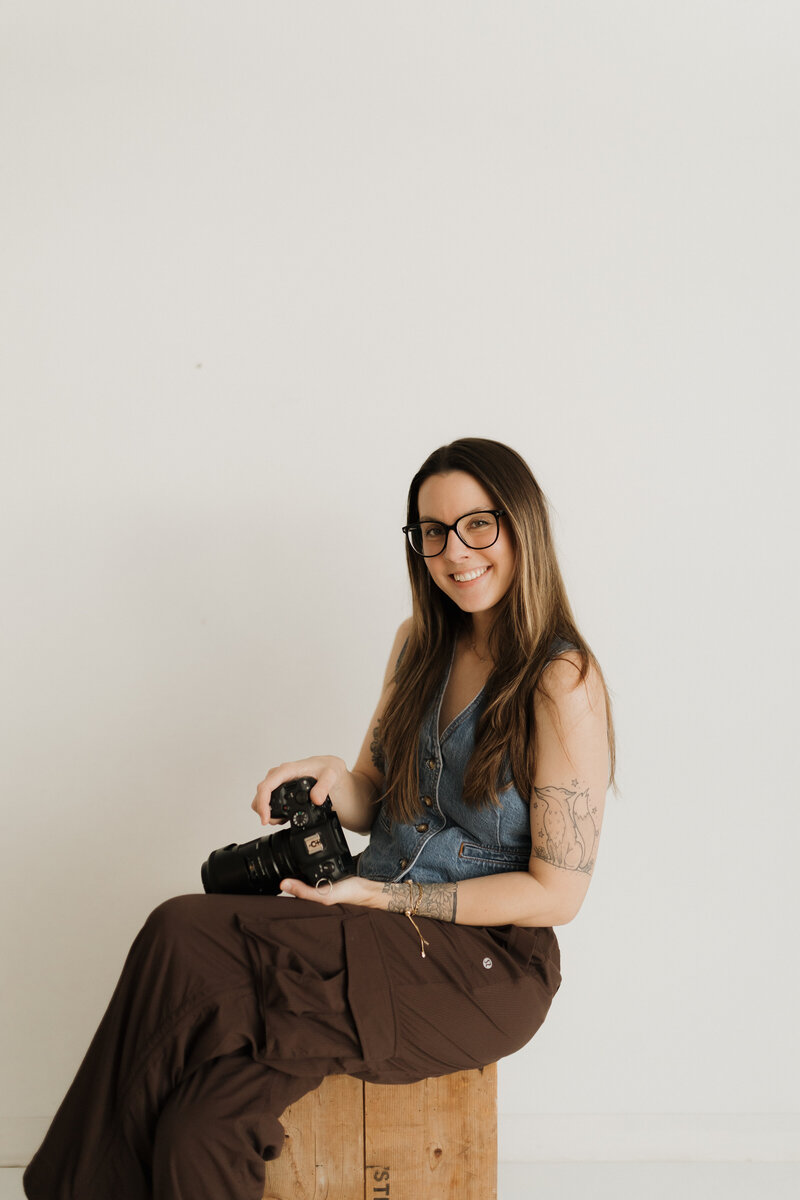 photo of a langley family & newborn photographer holding a film camera taken in black and white