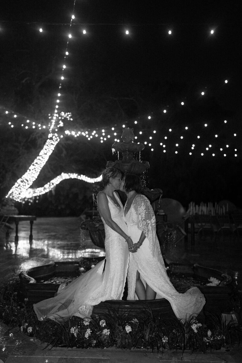 Brides kissing at ourdoor wedding reception