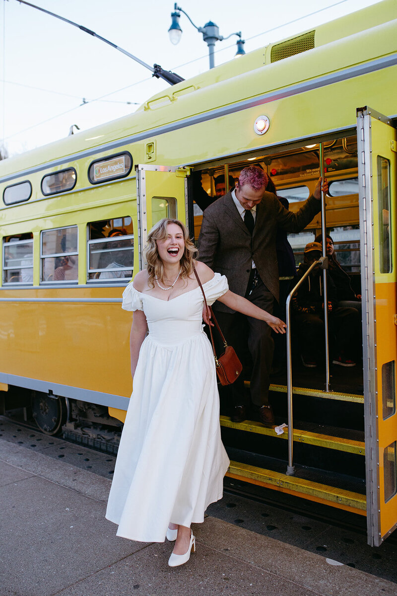 A bride and groom get off a train on their wedding day in San Francisco
