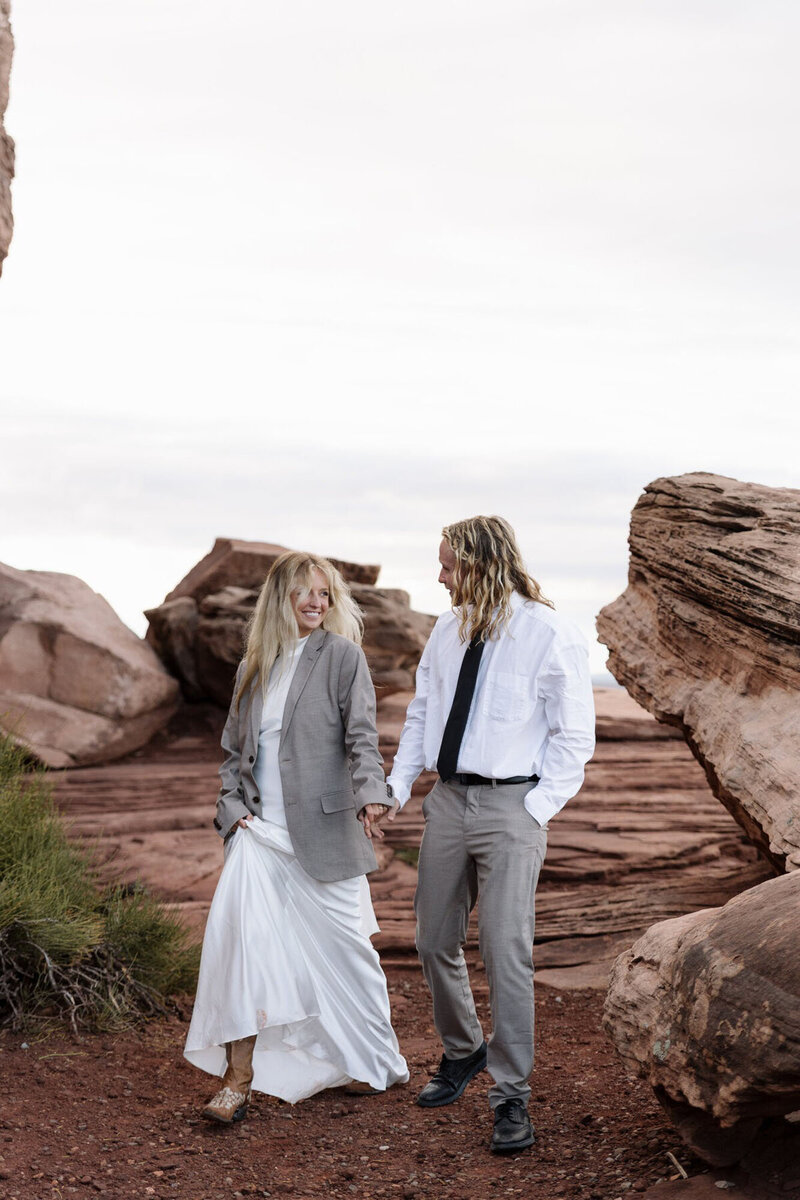 Bride and groom holding hands, captured by Moab elopement photographers at Forever Framed by Rachel