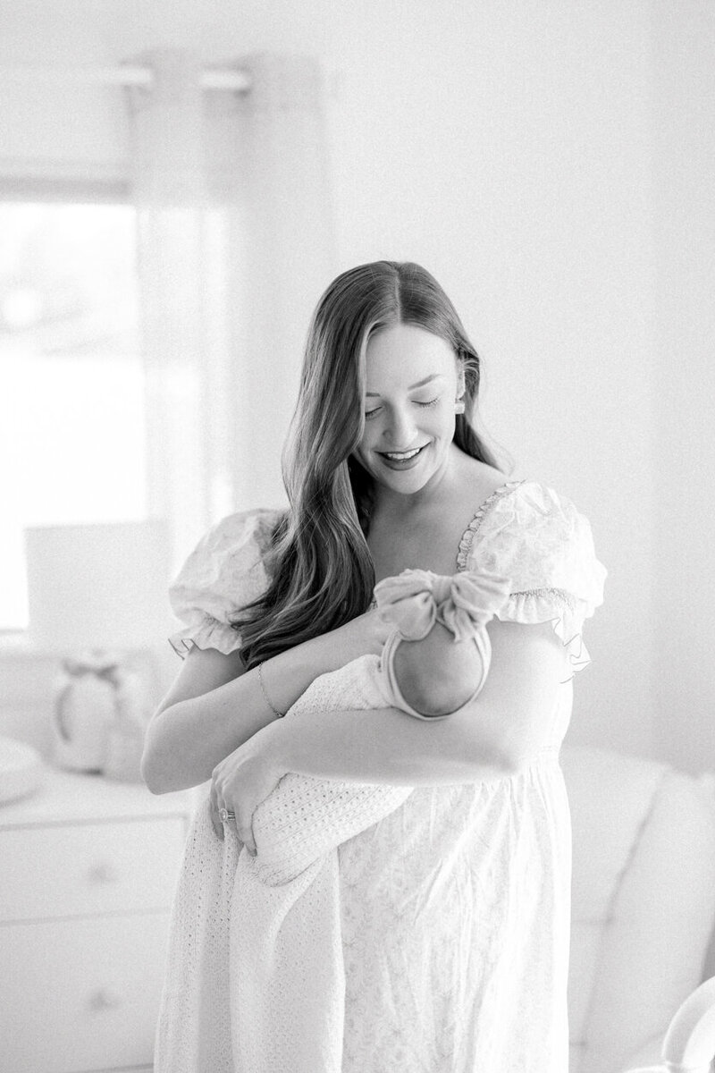 mom holding baby in nursery