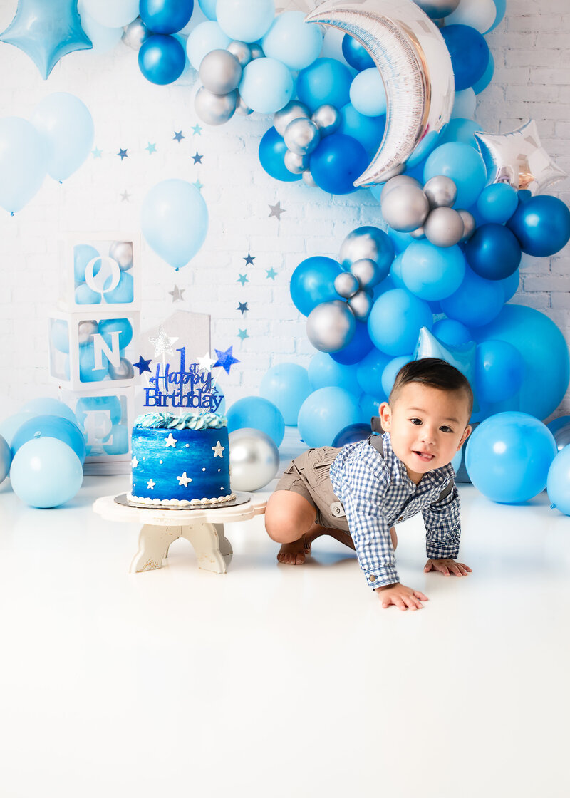 One year old boy cake smash photo in blue and silver balloon set – Birmingham cake smash photographer
