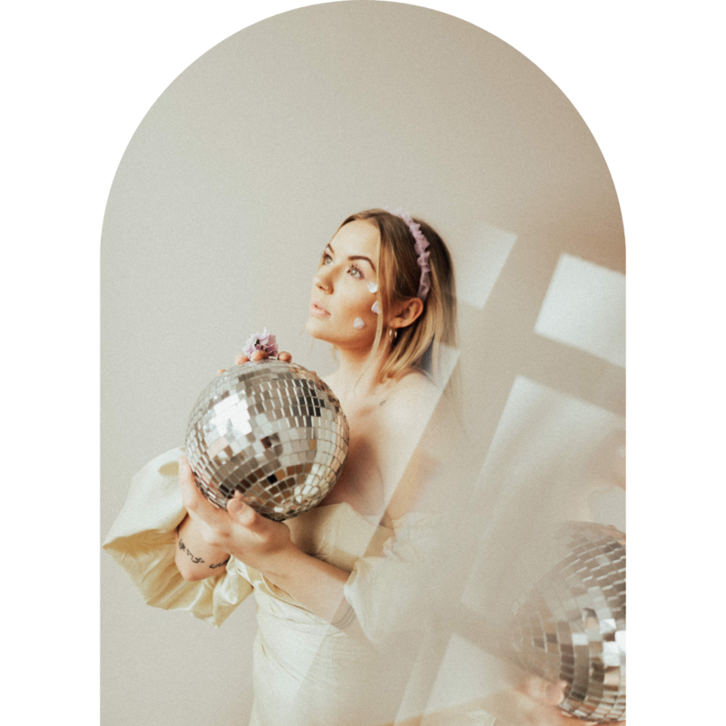 Bride holding a disco ball and looking up