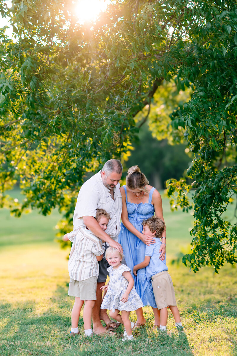 Family of five embracing during an outdoor session with Allen family photographer