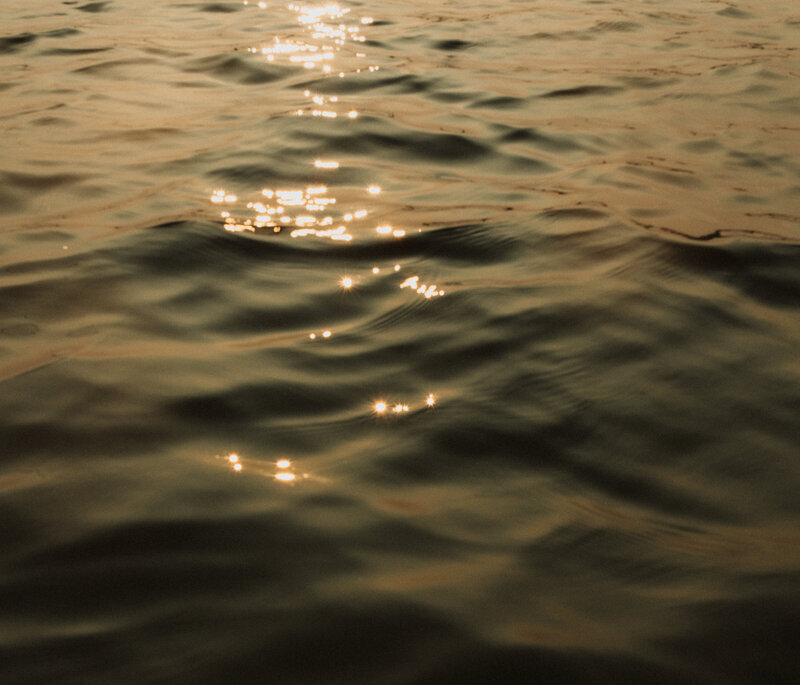 Serene water reflecting sunlight, representing destination wedding and elopement photography by Kayla Cassidy.