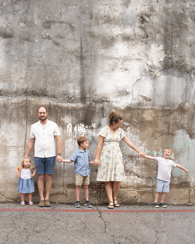 adorable family portrait in downtown mckinney against interesting wall