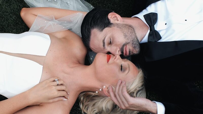 A newlywed couple laying head to head 