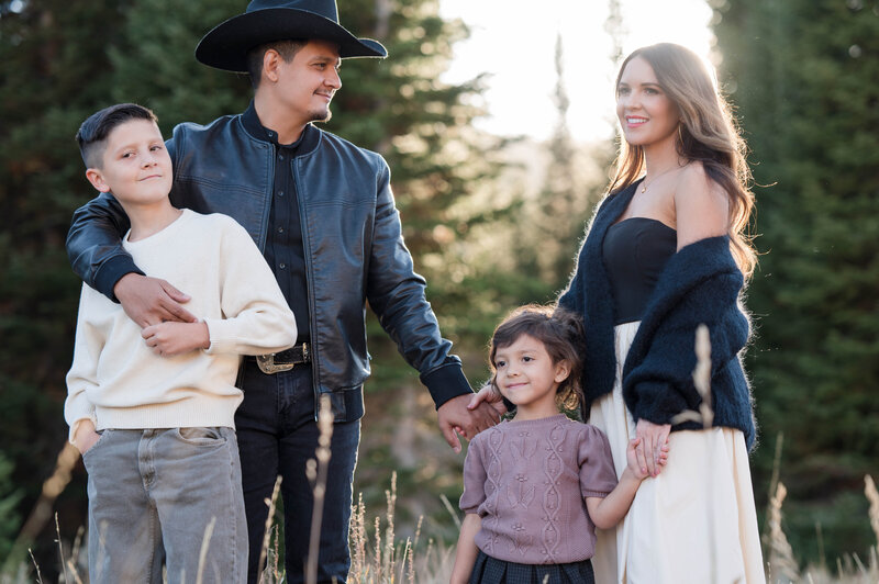 Family smiling on during their golden hour photo session in Draper, Utah
