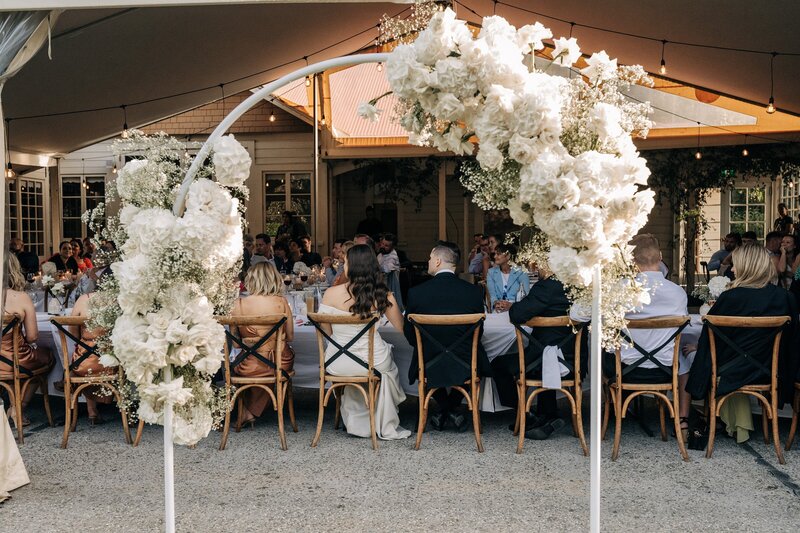 a white fresh floral archway in front of the reception area at the winehouse in queenstown