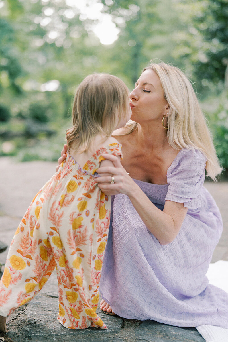 mom and daughter sharing kiss in atlanta park