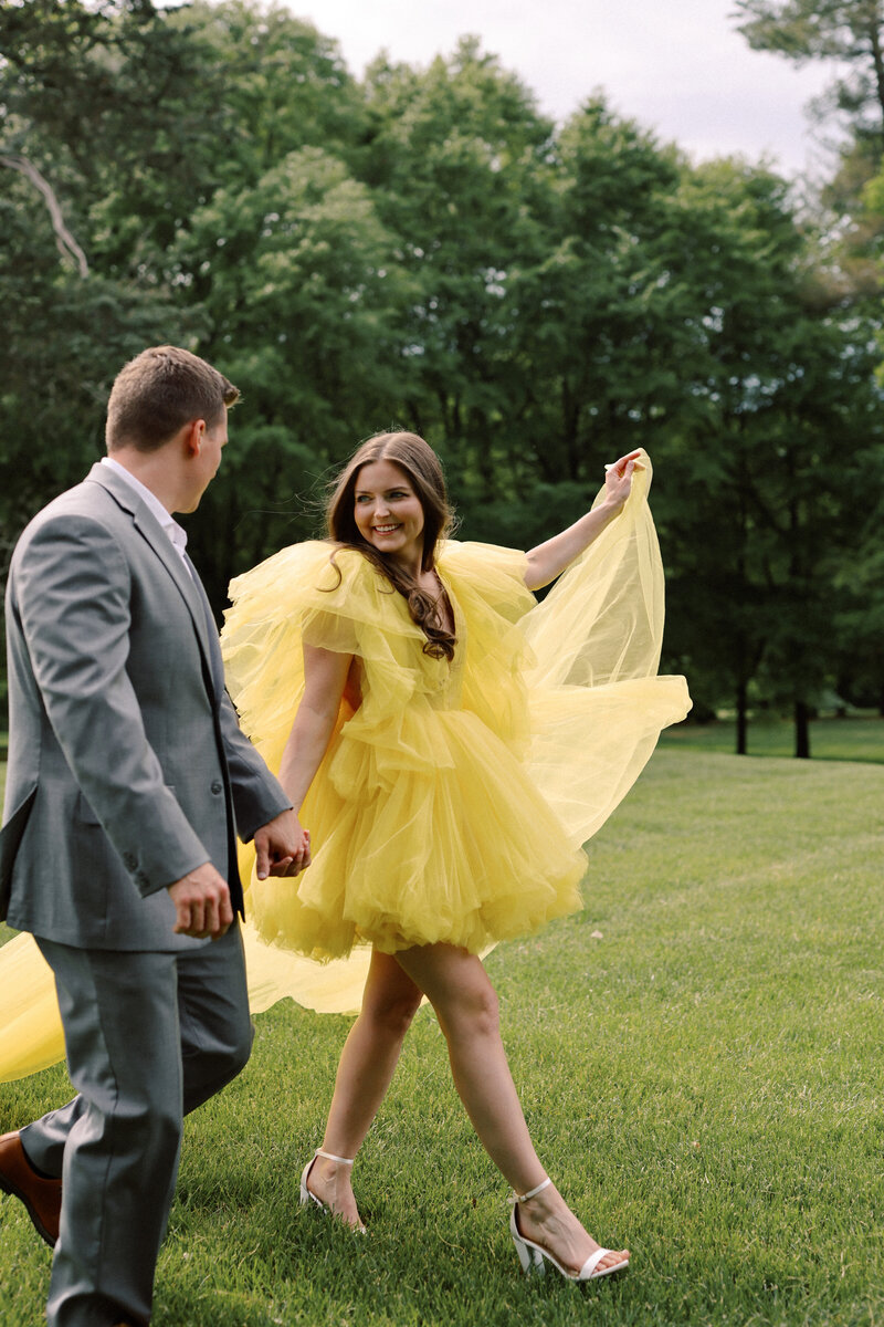 Cameron shares an emotional first look with his mother at Boxwood Estate. He stands in a beautifully landscaped area, looking at his mother as she smiles, holding back tears. Cameron is dressed in a sharp suit, while his mother wears an elegant dress. The soft natural light and the estate's picturesque setting create a heartfelt and intimate moment between mother and son, capturing the bond they share before the wedding.