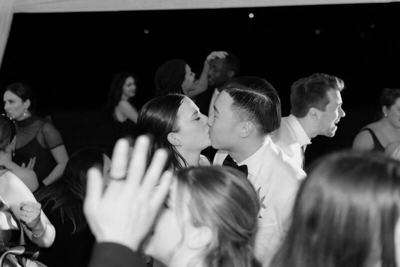 Couple share kiss on the dance floor at a New York themed wedding reception party. 