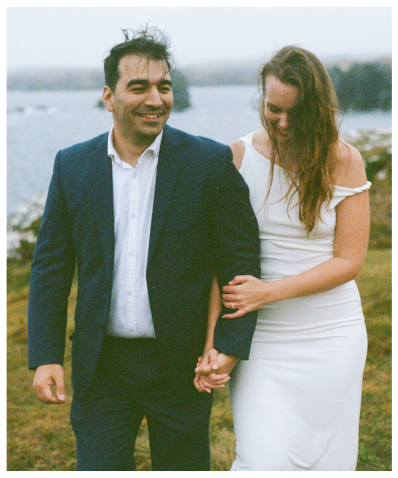 film photo of bride and groom beside foggy sea cliffs