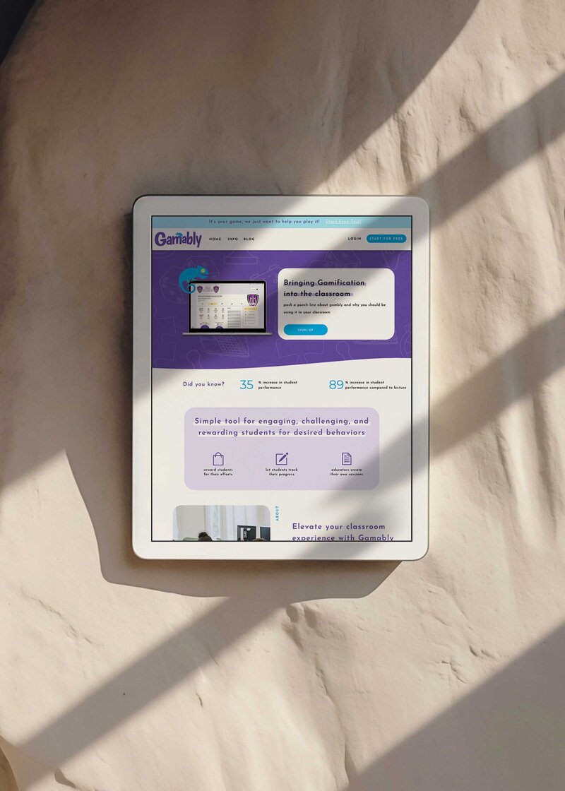 A tablet computer on a table displaying a vibrant purple screen, showcasing the gamably website by Unica Formo.