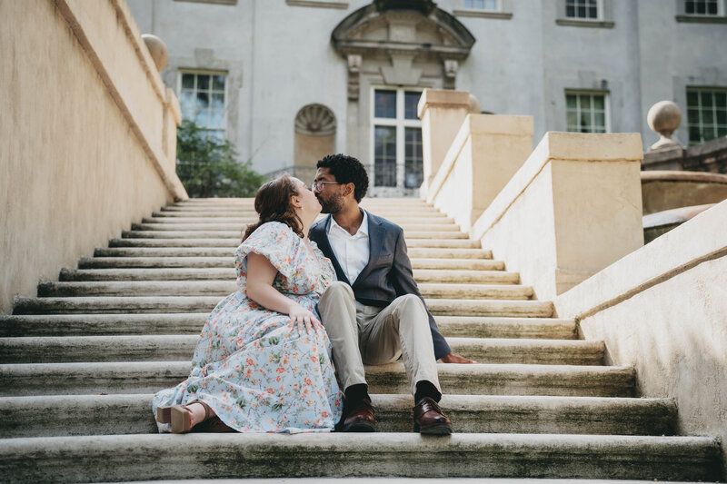 man and woman sitting on stairs kissing