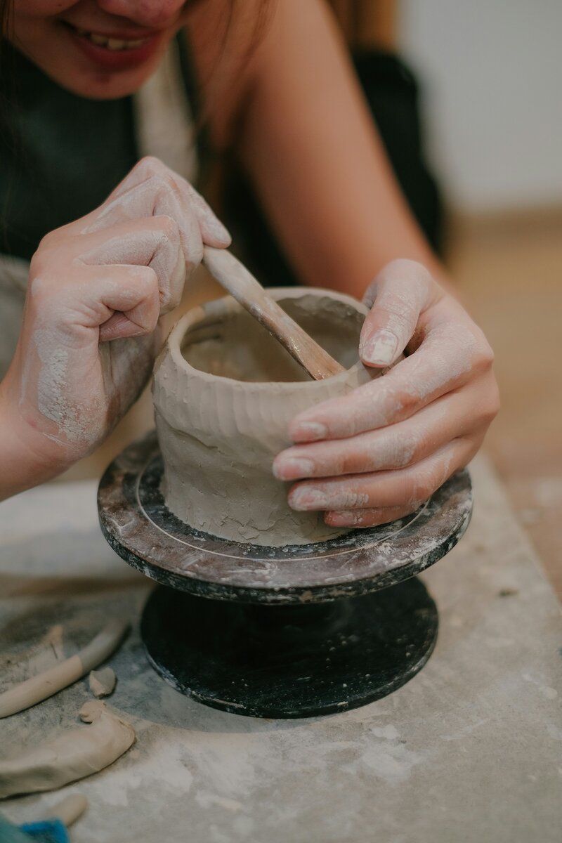 woman creating a clay pot