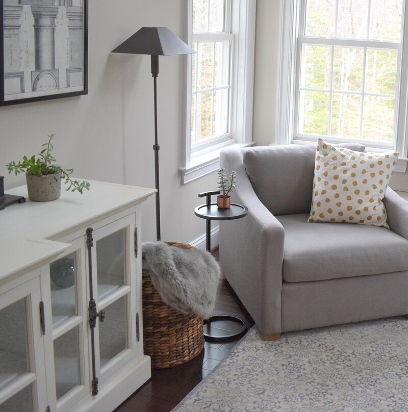 Grey floor lamp and drink table by chair