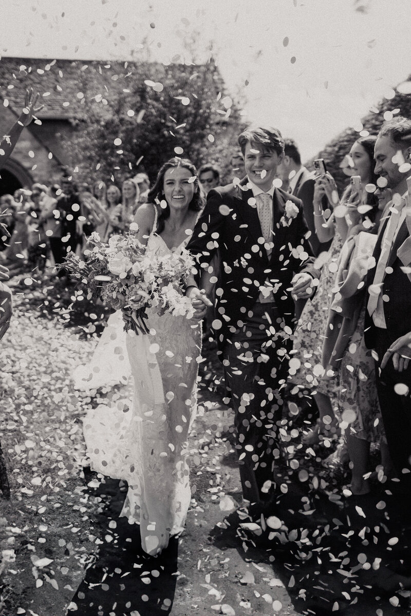Couple showered in confetti tunnel in Epsom Wedding