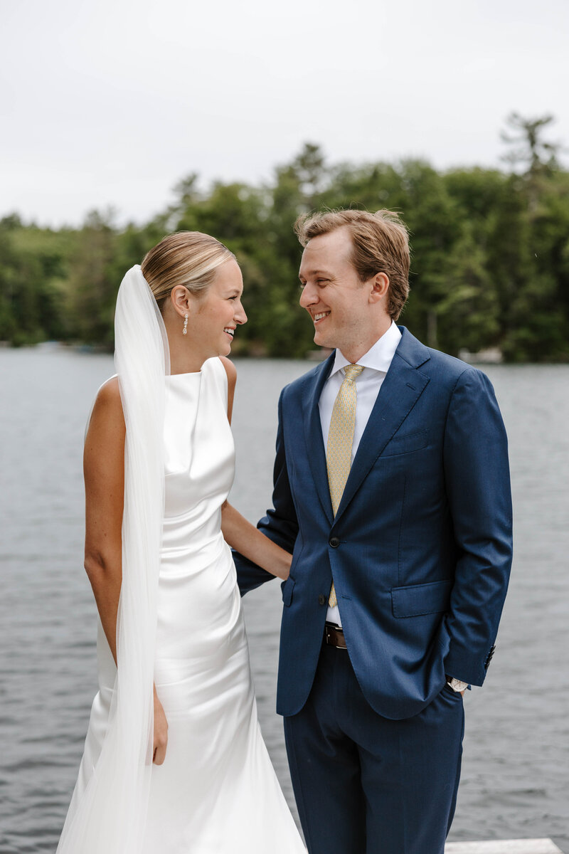 bride and groom looking at each other on their first look on their wedding day in camden, maine on a dock