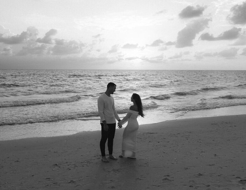 couple holding hands on the beach during sunset taken by engagement photographer naples fl