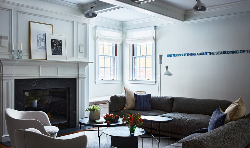 Boston interior decorator designs a modern family room in a historic Concord home, blending contemporary art with traditional architectural details.