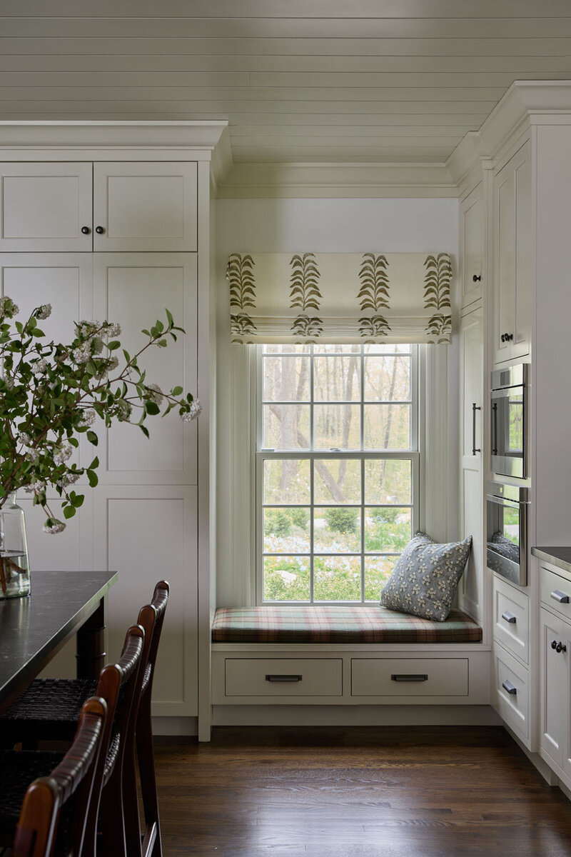 Window seat in the kitchen with white cabinets