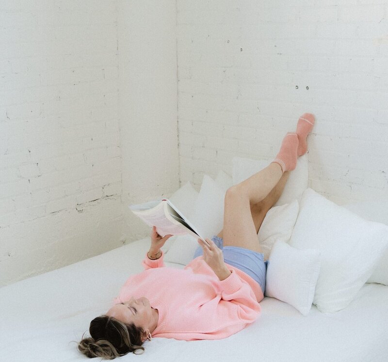 Integrative health coach practicing restorative self-care, reading about menopause in a calming, hormone-supportive setting