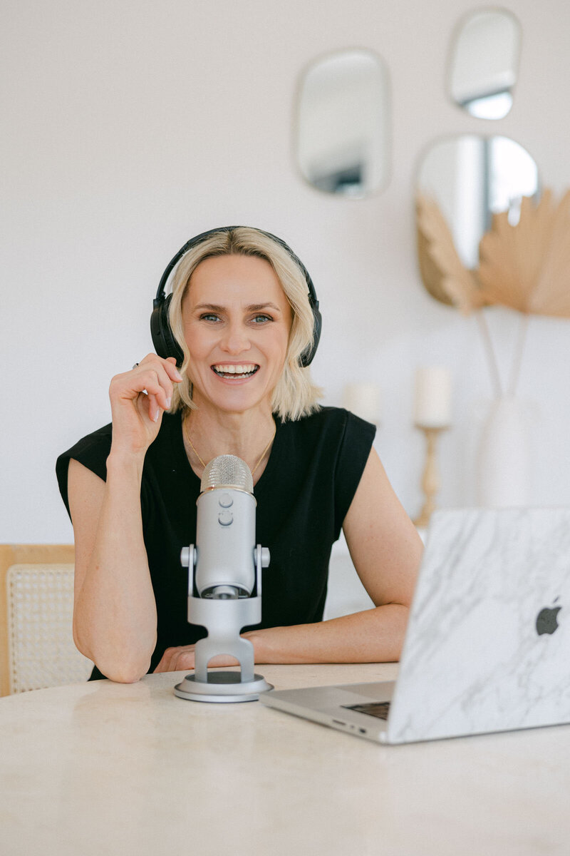 Zelda Green, smiling at camera whilst recording her Good with Money podcast with a guest