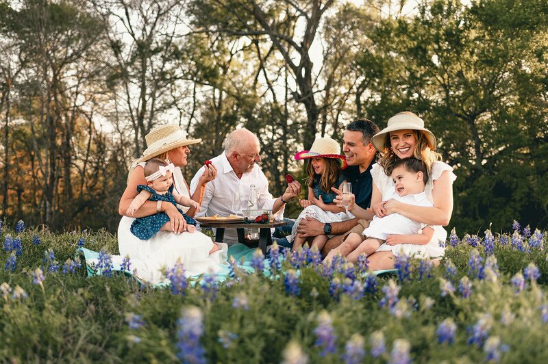 extended family eating strawberries in the bluebonnets by Cypress Family Photographer