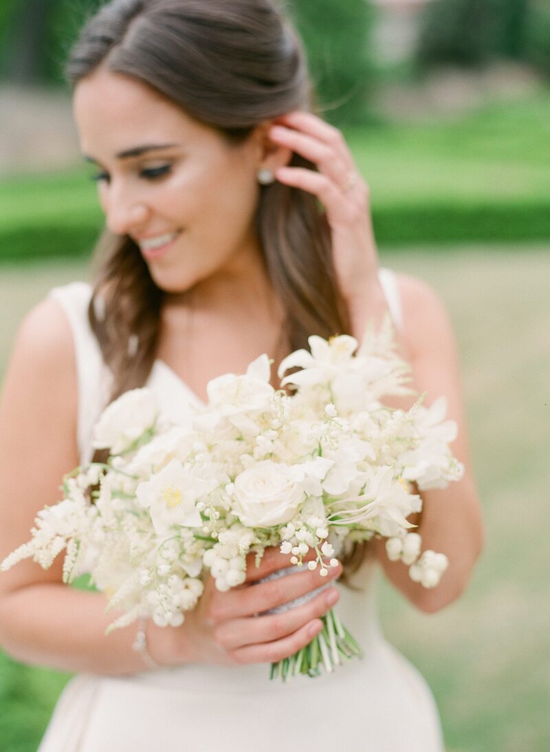 A bride holds an all white Anthousai bouquet in Tulsa.