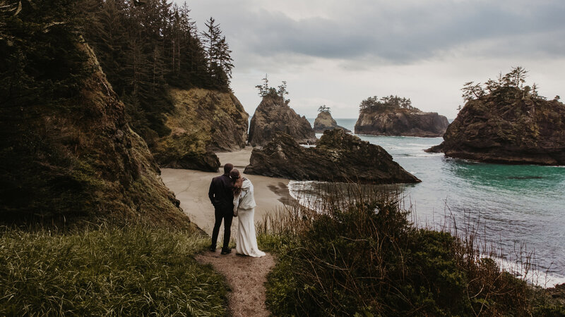Couple looking out at Secret Beach during their adventure elopement near Brookings