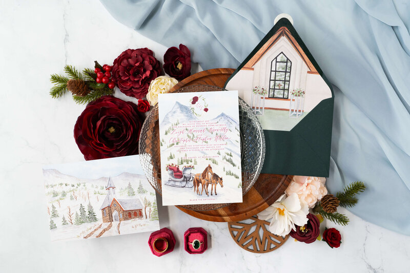 Invitation flatlay for Beaver Creek winter wedding, showcasing elegant design elements: snowy watercolor map, dark green, and burgundy accents