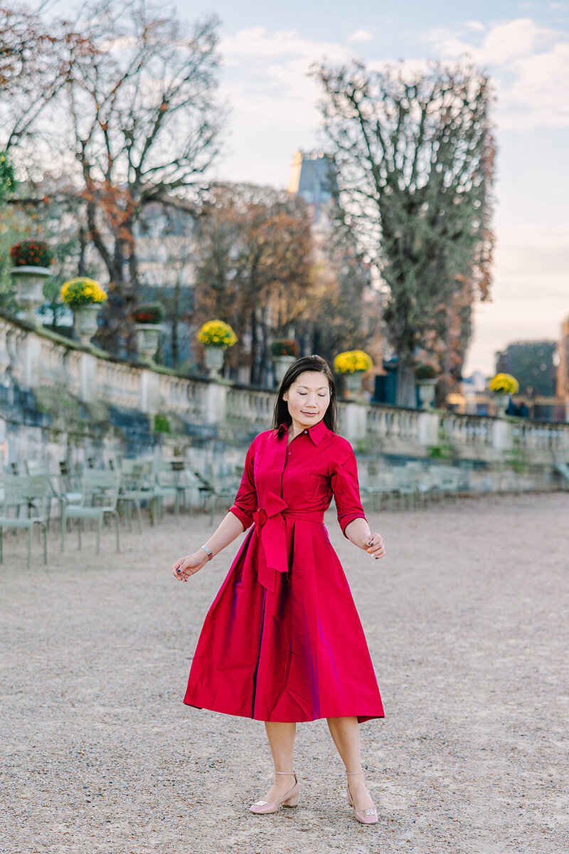 Solo woman in a pink maxi dress during a Paris photoshoot on Île Saint-Louis in the city center.