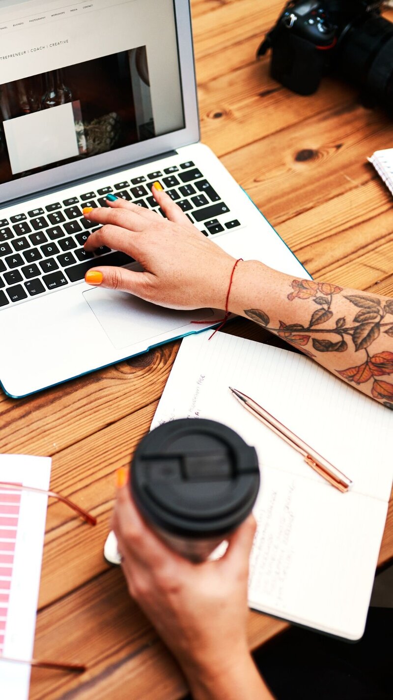 Julie Wenzlick working on SEO strategy at laptop with coffee and brand materials on desk