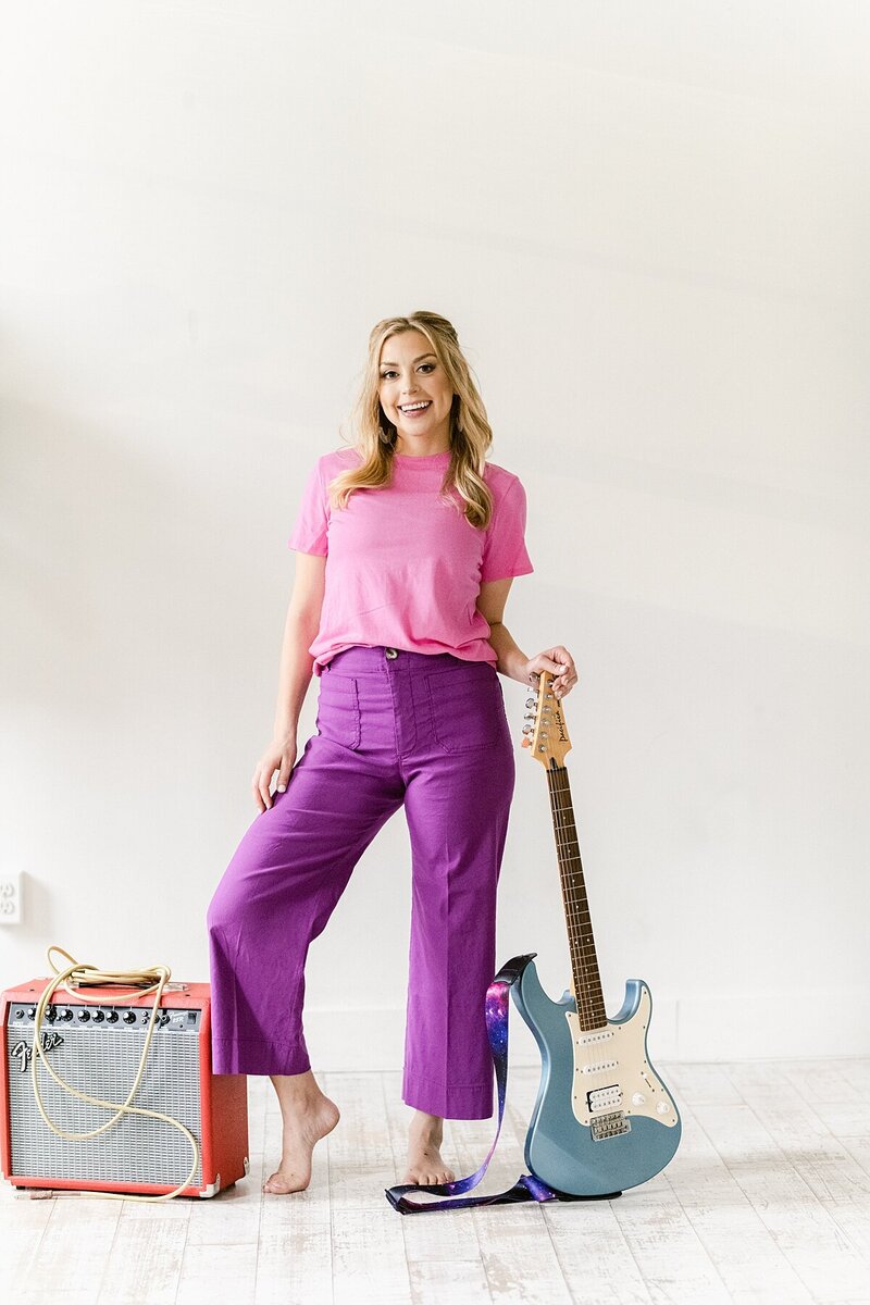 Woman posing with a guitar and amp