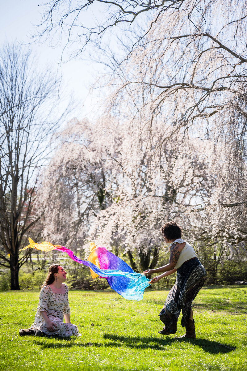 A couple enjoys their time basking in the sun and playing with silk fans during their elopement wedding day in Blacksburg, Virginia.