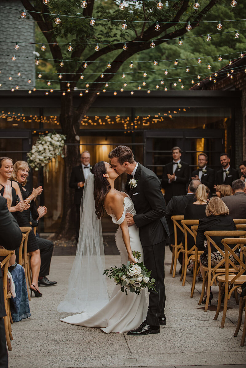 Couple Kisses in the aisle at The My. Washington Mill Dye House