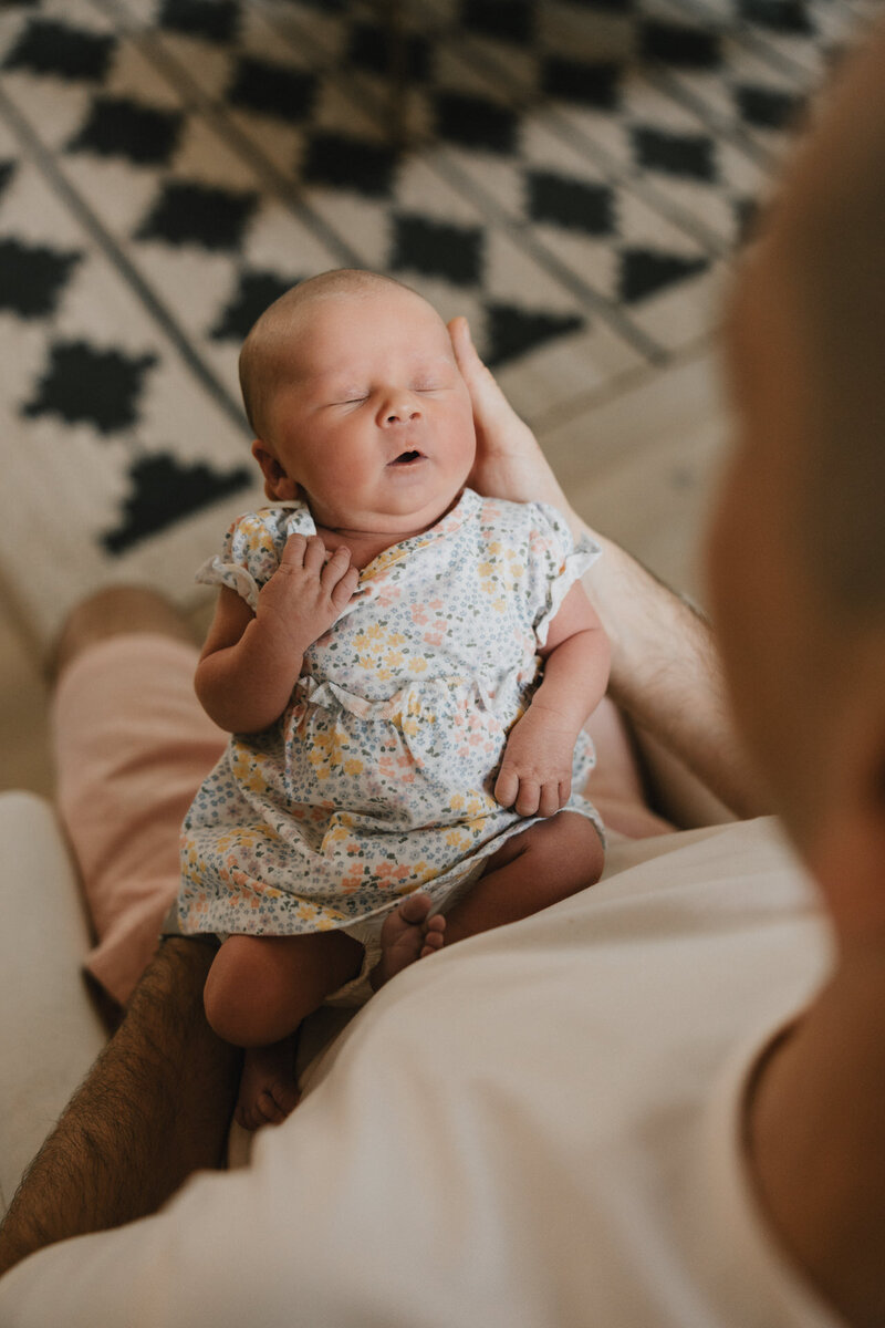 Timeless black and white newborn photo featuring a baby lying on crisp white sheets