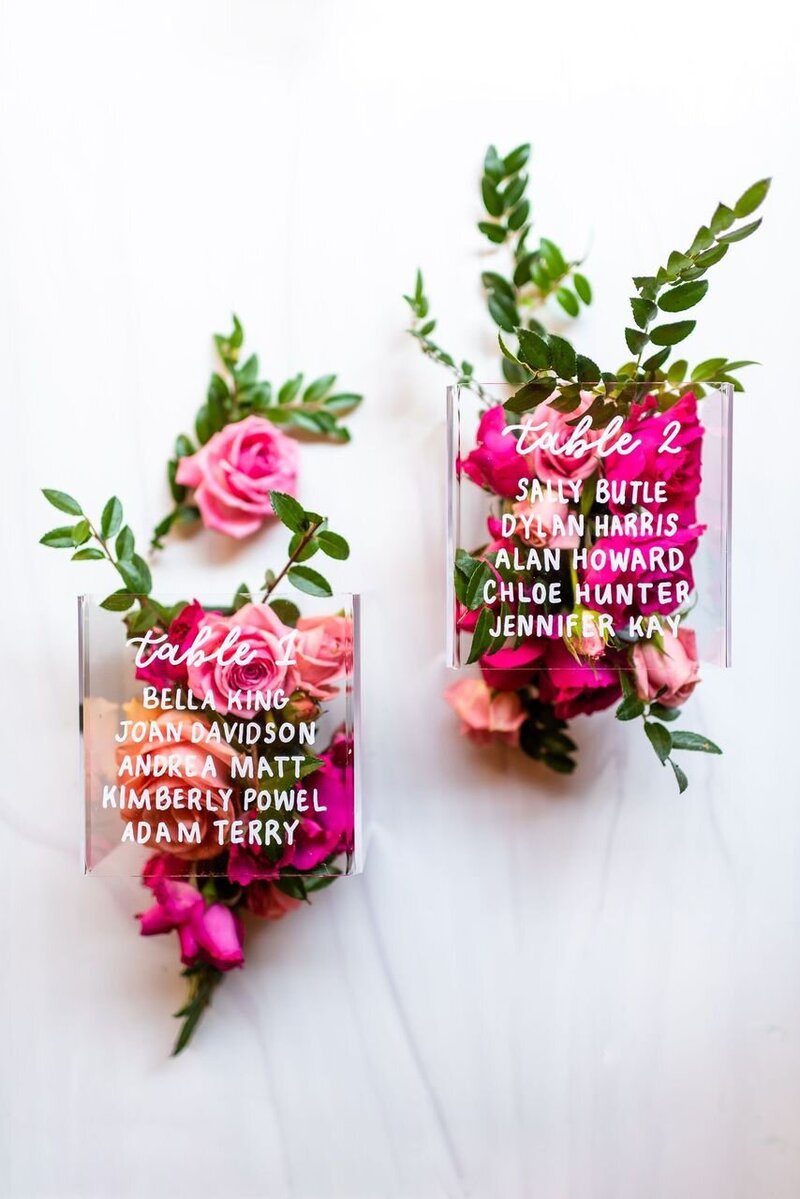 wedding reception table numbers with bright pink flowers