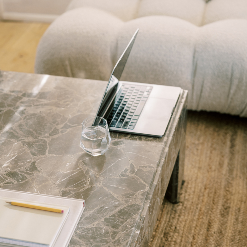 Woman in white suit sitting on a couch, representing professional custom web design consultations by The Agency.