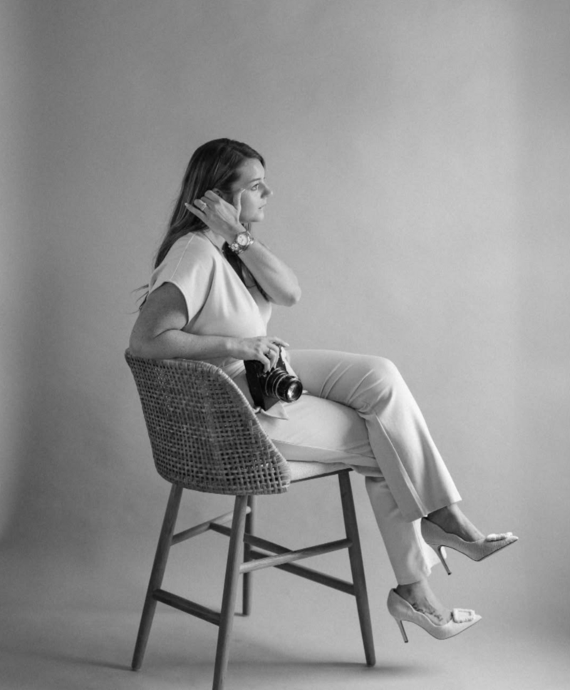 Woman sits on chair holding film camera