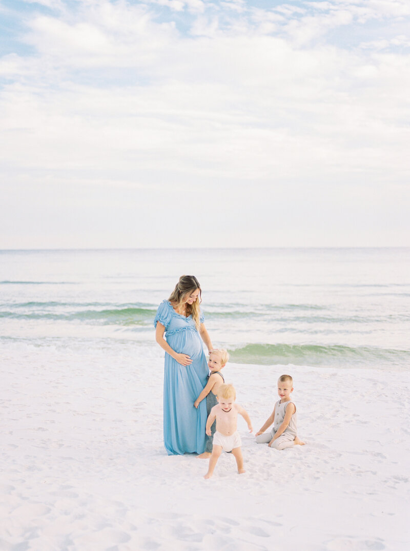 expecting mother with her 4 sons at the beach from Orlando maternity photographer