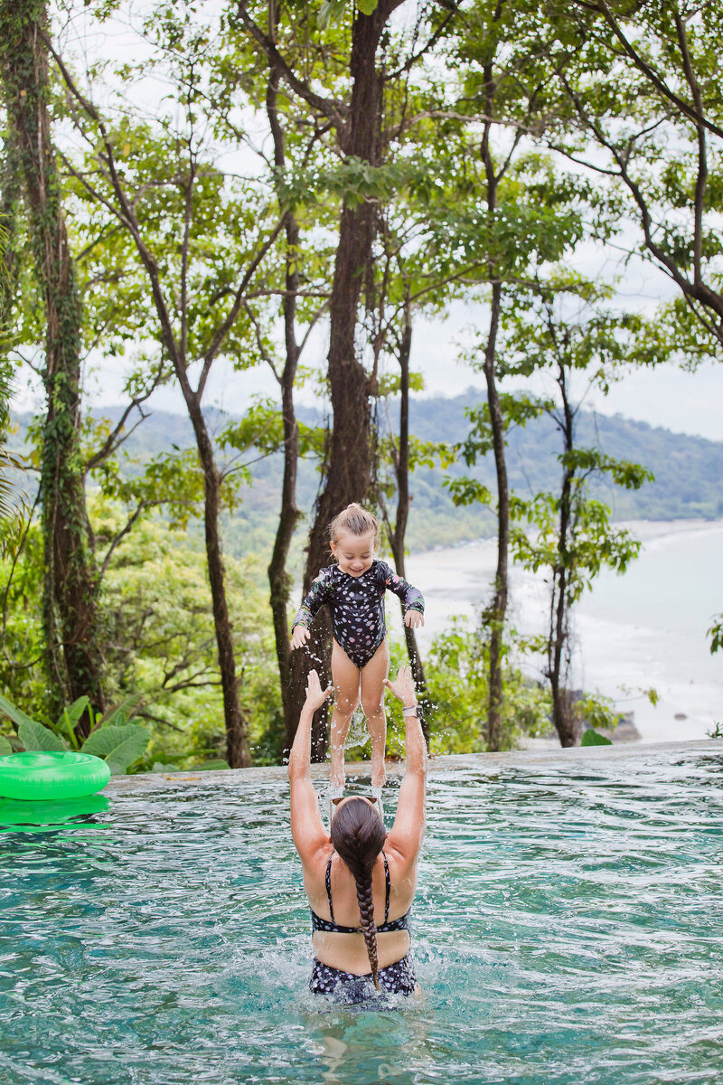 A heartwarming moment of a traveling mom throwing her daughter in the air while enjoying the pool at Arenas del Mar in Manuel Antonio. Create cherished family memories in Costa Rica.