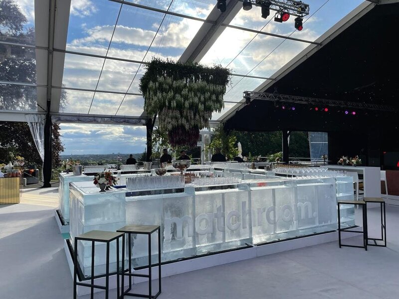 A large double pole marquee sitting on top of a hill with a view of the land below.