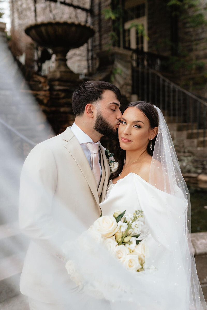 Groom kissing bride's cheek