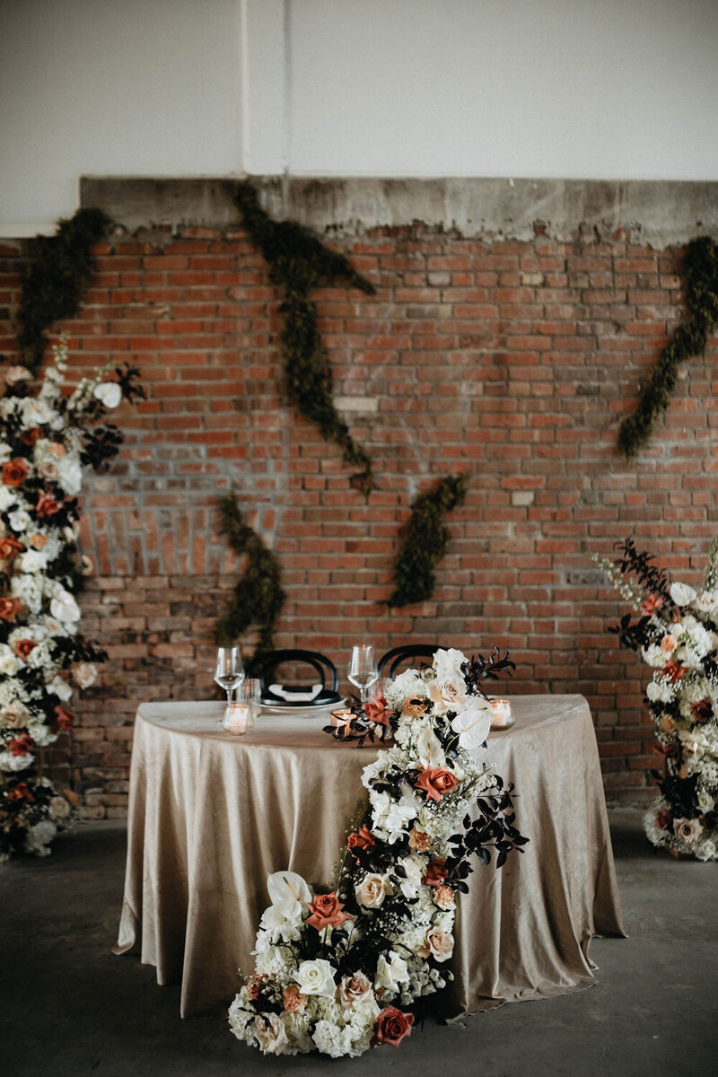 Head table at the wedding reception with florals.