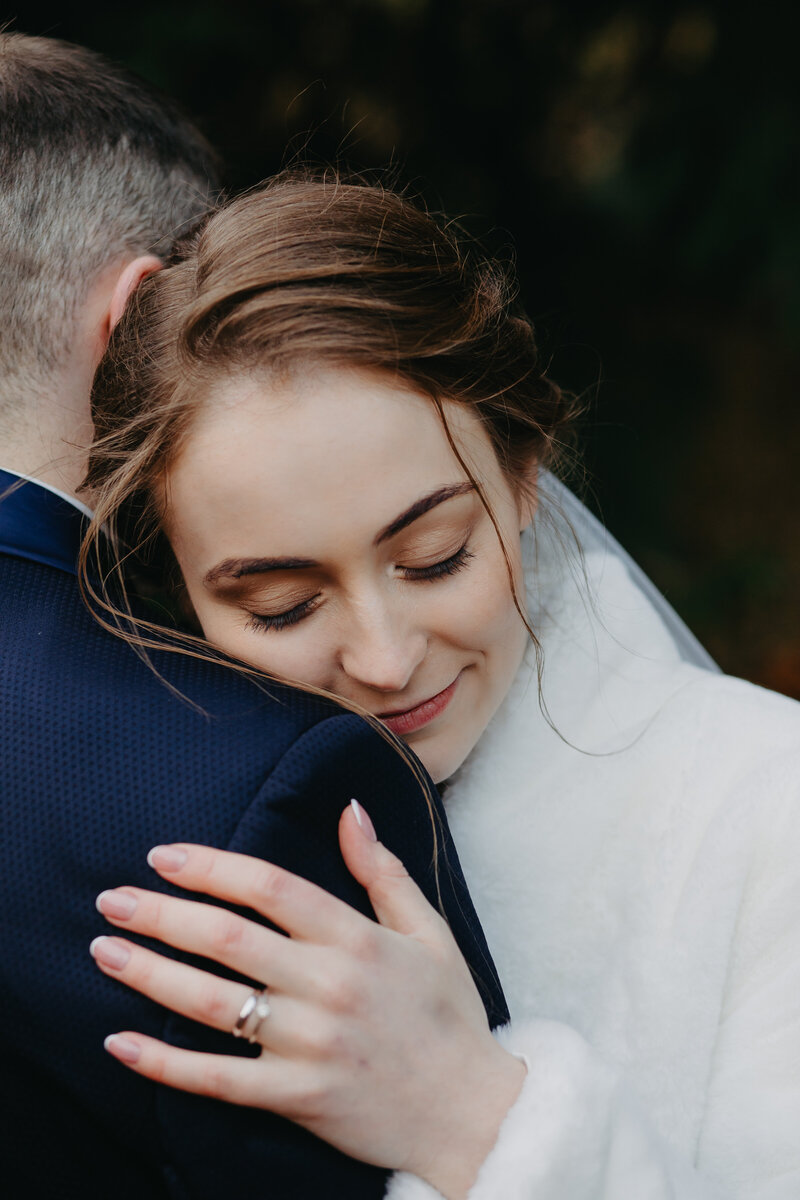 Bride resting her head on the groom’s shoulder with her eyes closed, capturing a peaceful and emotional moment of connection at Trim castle.