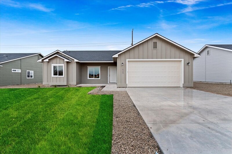 gray house with landscaping in front on a quiet street