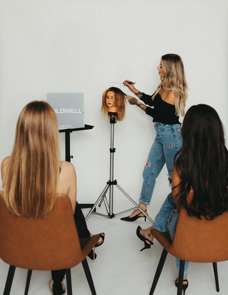 Hairstylist with tattoos sitting in salon chair