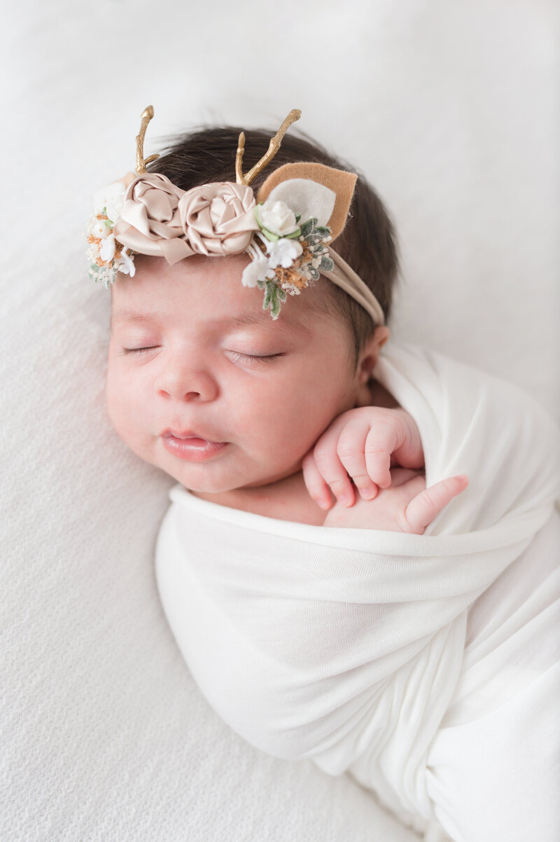 Newborn baby girl sleeping swaddled during nj portrait session.